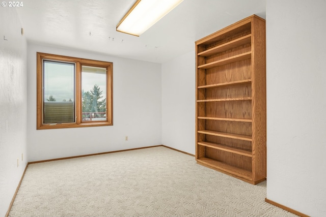 empty room featuring baseboards and carpet flooring