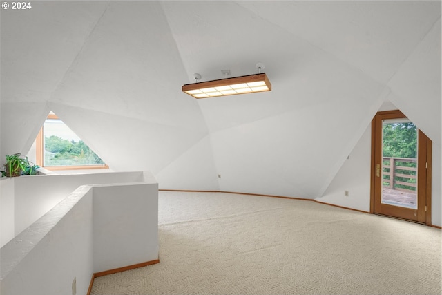 additional living space with vaulted ceiling and carpet floors