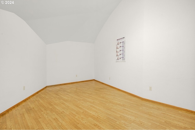 additional living space with vaulted ceiling, baseboards, and wood finished floors