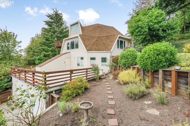 rear view of property with fence and roof with shingles