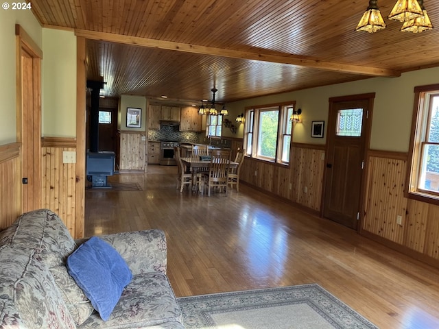 26231 SW Thunderhead Ln, Sheridan, OR 97378 - dining space with a chandelier, wainscoting, a wood stove, hardwood / wood-style floors, and wooden walls