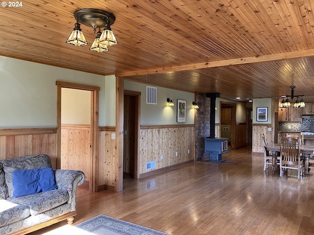 26231 SW Thunderhead Ln, Sheridan, OR 97378 - living room with a wainscoted wall, a wood stove, hardwood / wood-style floors, wooden walls, and wooden ceiling