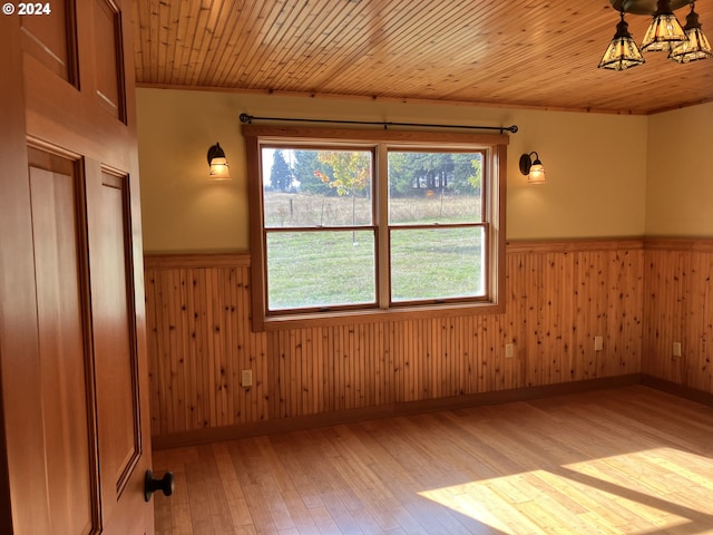 26231 SW Thunderhead Ln, Sheridan, OR 97378 - spare room with a wainscoted wall, plenty of natural light, light wood-style floors, wooden walls, and a chandelier