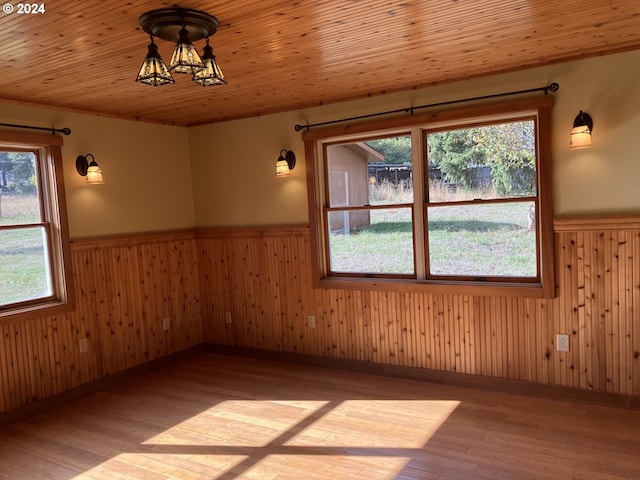 26231 SW Thunderhead Ln, Sheridan, OR 97378 - spare room featuring a wainscoted wall, healthy amount of natural light, light wood finished floors, wood walls, and a chandelier