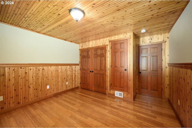 26231 SW Thunderhead Ln, Sheridan, OR 97378 - empty room featuring wooden walls, wainscoting, light wood-style flooring, and wooden ceiling