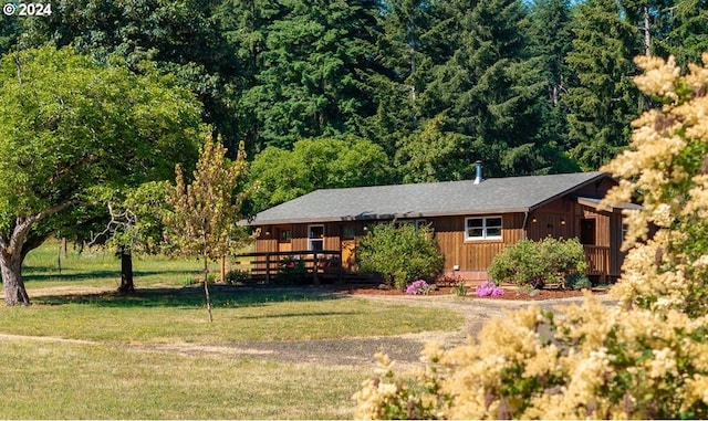 ranch-style home featuring a wooden deck and a front yard