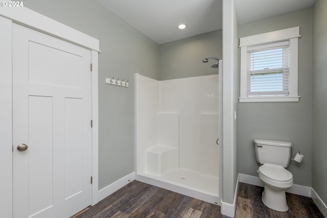 bathroom with walk in shower, toilet, and wood-type flooring