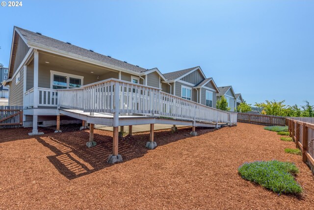 rear view of property featuring a wooden deck