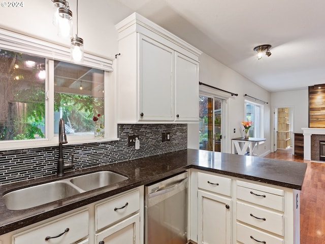 kitchen featuring pendant lighting, sink, white cabinets, and stainless steel dishwasher