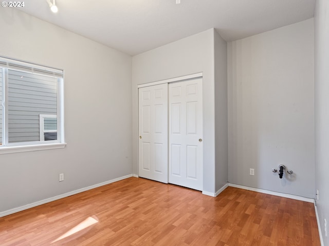 unfurnished bedroom featuring a closet and light hardwood / wood-style flooring