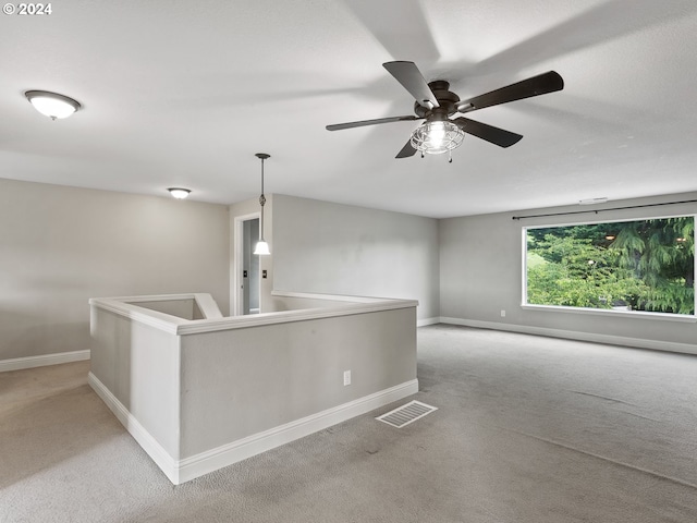 empty room featuring ceiling fan and light colored carpet