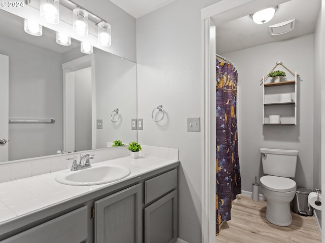 bathroom with wood-type flooring, vanity, and toilet