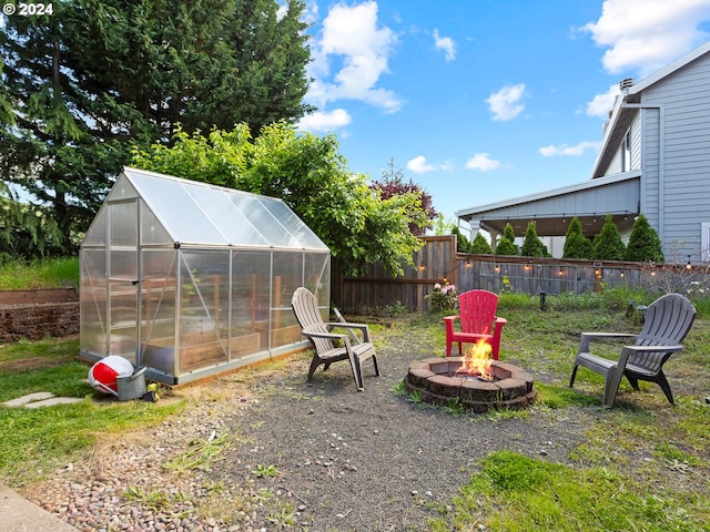 view of yard with a fire pit and an outdoor structure