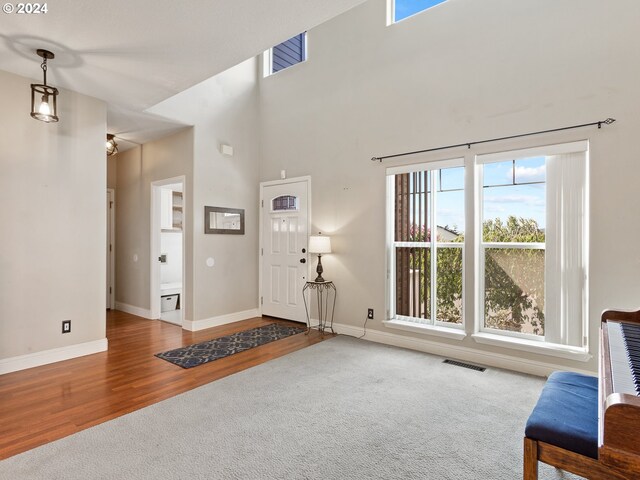 carpeted foyer featuring a high ceiling