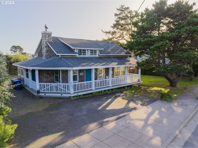 farmhouse with covered porch and a yard