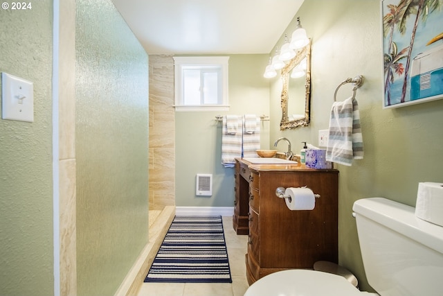 bathroom with tile patterned floors, vanity, walk in shower, and toilet