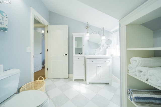 bathroom with vanity, toilet, and lofted ceiling