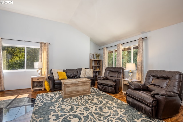 living room featuring wood-type flooring, vaulted ceiling, and a wealth of natural light