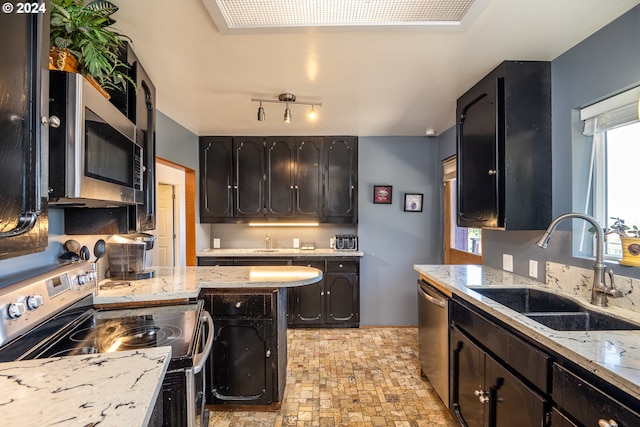 kitchen with appliances with stainless steel finishes, sink, and light stone counters