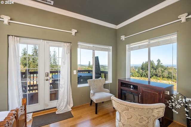 sitting room featuring french doors, light hardwood / wood-style flooring, and ornamental molding