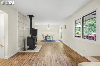 unfurnished living room featuring wood-type flooring and a wood stove