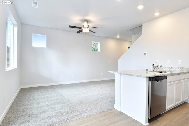 kitchen with white cabinets, stainless steel appliances, light stone countertops, and light wood-type flooring