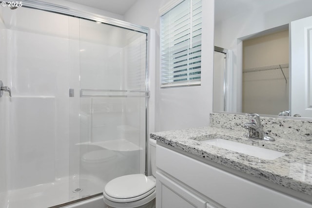 bathroom with vanity, toilet, and an enclosed shower