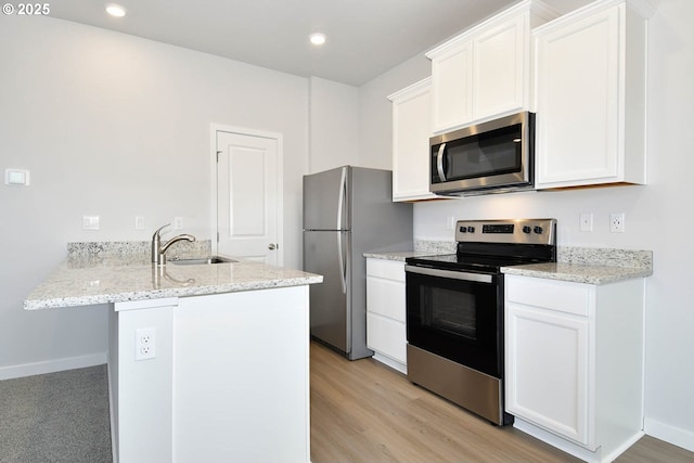 kitchen with ceiling fan, appliances with stainless steel finishes, light colored carpet, white cabinetry, and light stone countertops