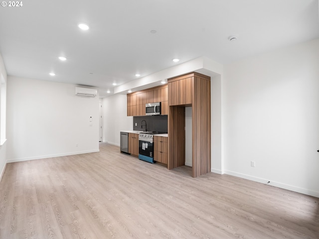 kitchen with light wood-type flooring, stainless steel appliances, and a wall mounted AC