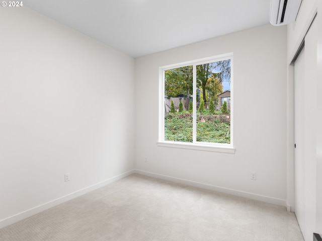 unfurnished bedroom featuring light colored carpet, an AC wall unit, and a closet