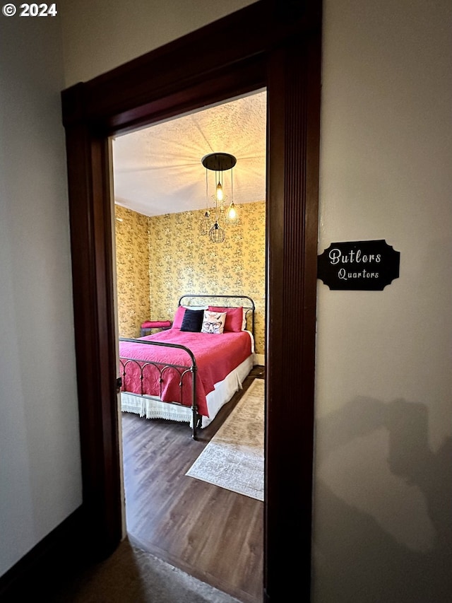 bedroom with a notable chandelier and wood-type flooring