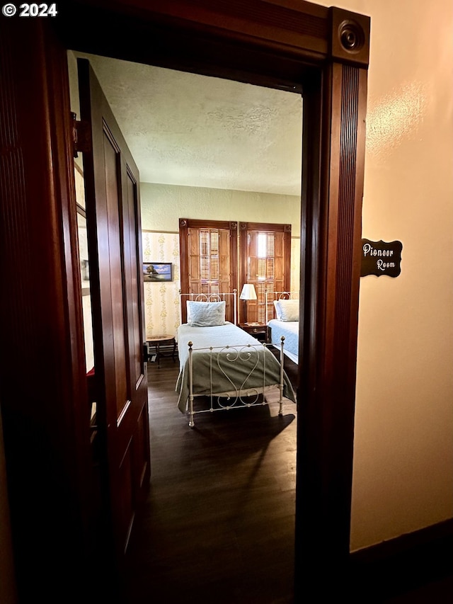 bedroom featuring a textured ceiling and dark hardwood / wood-style floors