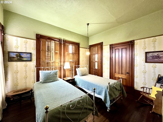 bedroom with a textured ceiling and dark wood-type flooring