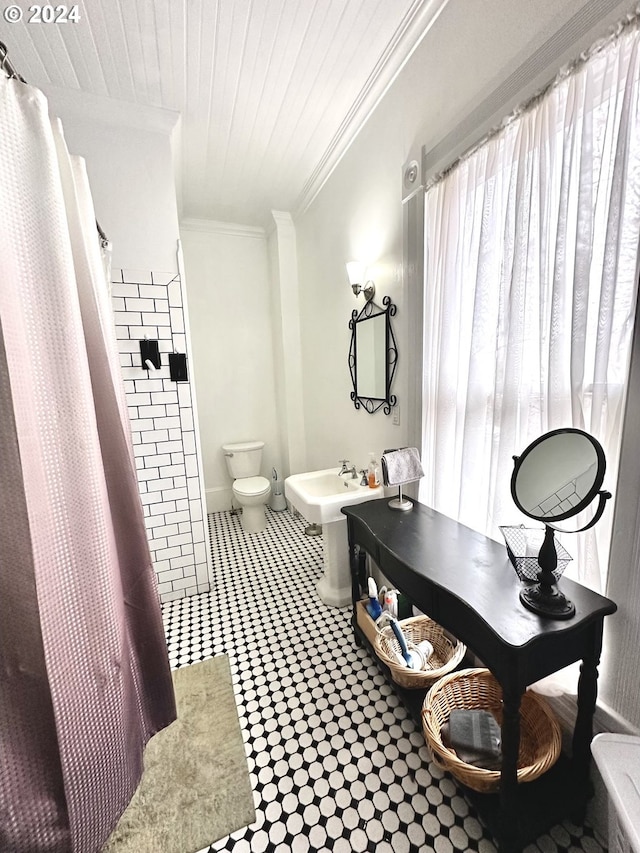 bathroom featuring a shower with shower curtain, toilet, ornamental molding, and sink