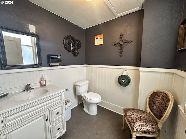 bathroom featuring vanity, toilet, and a textured ceiling