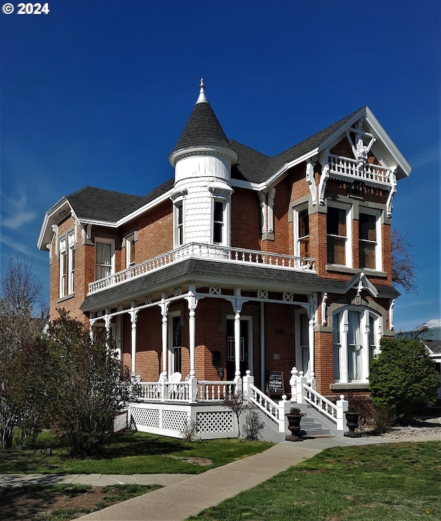 victorian-style house featuring a balcony and covered porch