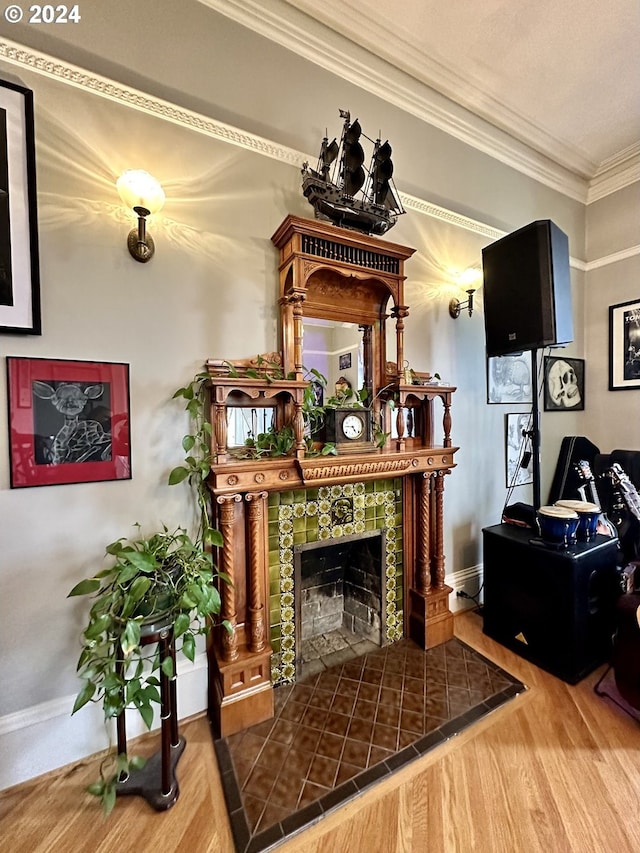 sitting room featuring hardwood / wood-style flooring, ornamental molding, and a tiled fireplace