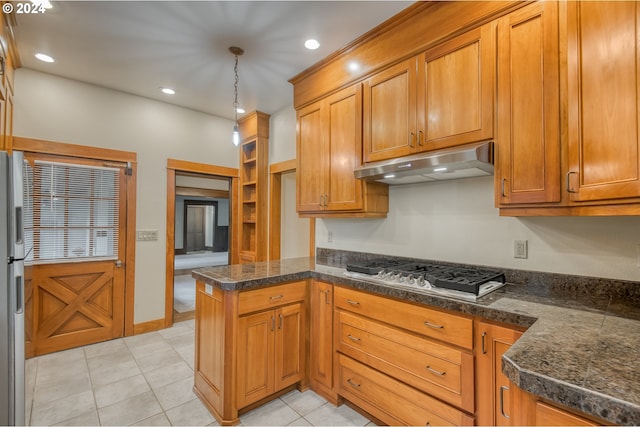 kitchen featuring kitchen peninsula, appliances with stainless steel finishes, decorative light fixtures, and light tile patterned floors