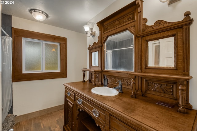 bathroom with curtained shower, hardwood / wood-style floors, and vanity