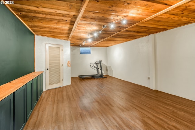 exercise room with vaulted ceiling, light hardwood / wood-style flooring, and wood ceiling