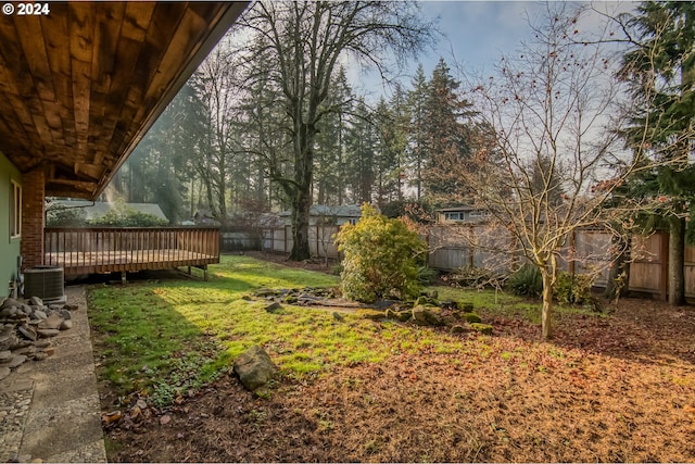 view of yard with central AC unit and a wooden deck