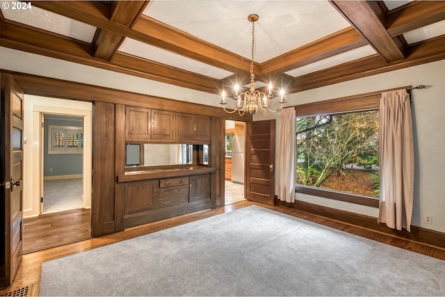 unfurnished living room with beamed ceiling, dark hardwood / wood-style floors, a chandelier, and coffered ceiling