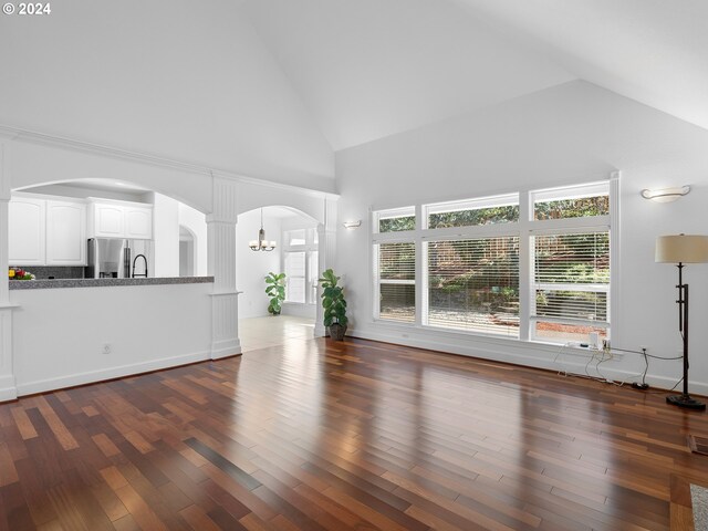 unfurnished living room with dark hardwood / wood-style flooring and high vaulted ceiling