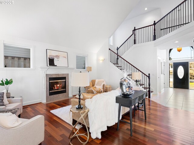 unfurnished living room featuring high vaulted ceiling, dark wood-type flooring, and a notable chandelier