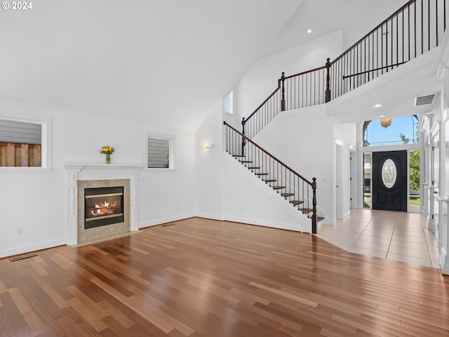 unfurnished living room featuring hardwood / wood-style floors and high vaulted ceiling