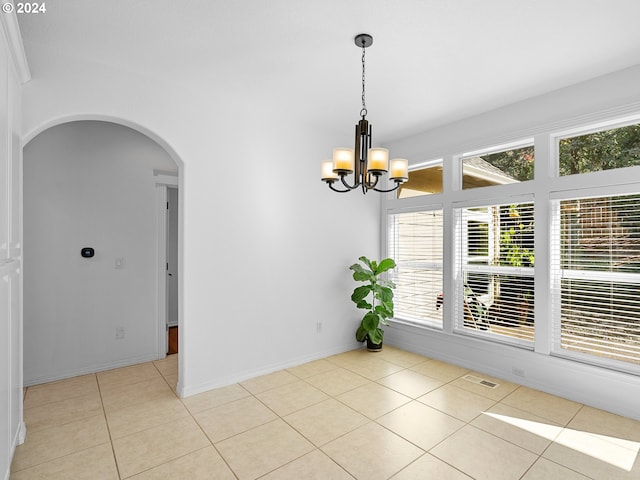 unfurnished room featuring light tile patterned flooring and an inviting chandelier