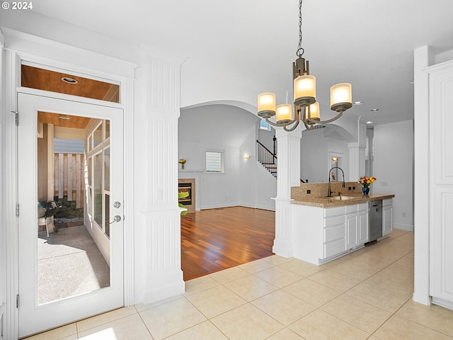 kitchen with white cabinetry, sink, an inviting chandelier, light hardwood / wood-style floors, and decorative light fixtures