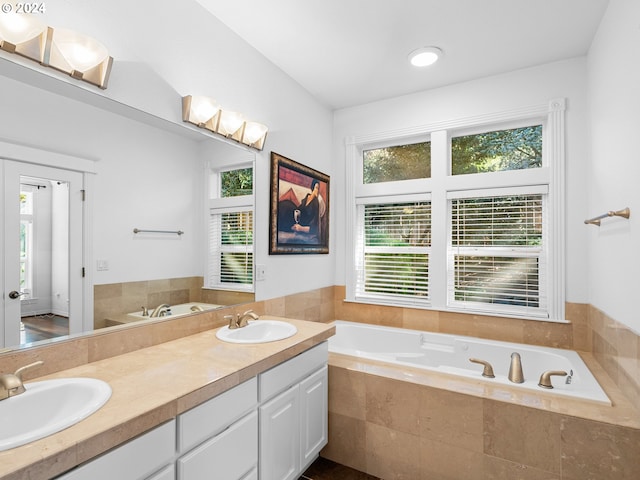 bathroom featuring vanity and tiled bath