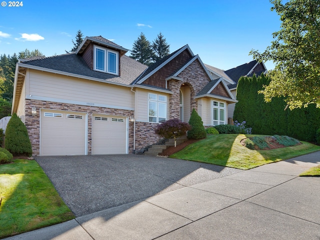 craftsman inspired home with a front yard and a garage