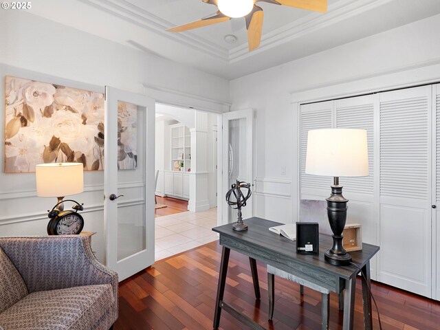 unfurnished dining area featuring hardwood / wood-style flooring, a notable chandelier, built in features, and a tray ceiling